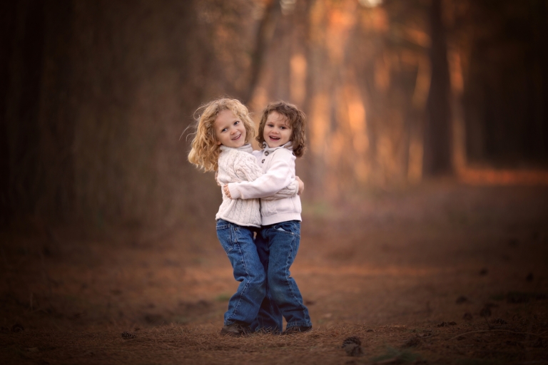 Two brothers hugging on a cold day with a blurred background. 