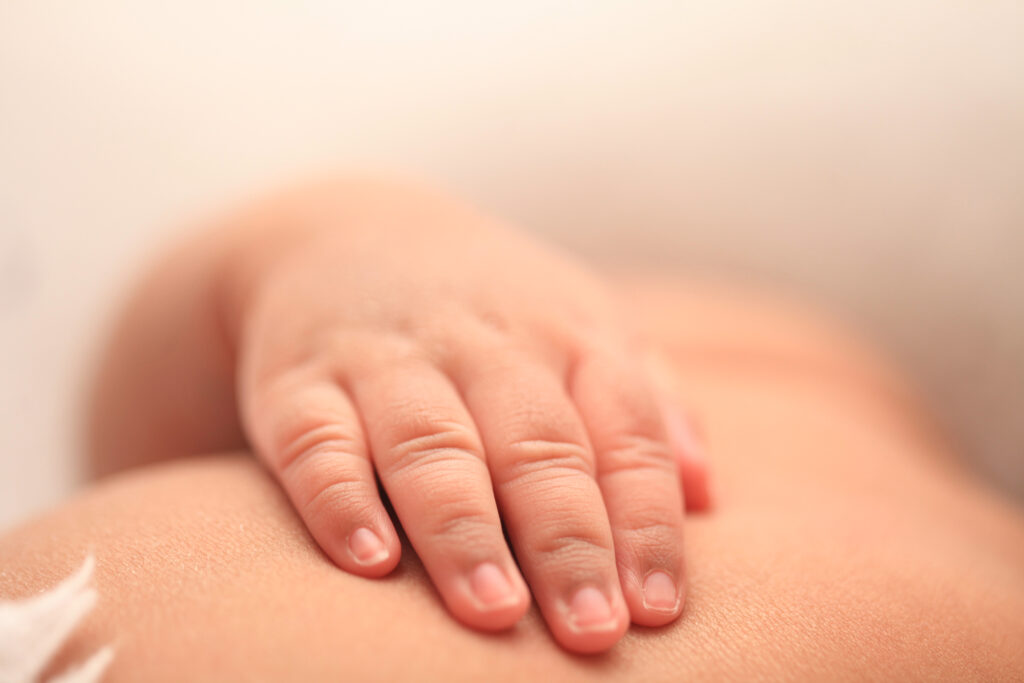 Close up of a newborn baby's hand resting on its chest during a newborn photography session in Raleigh, NC